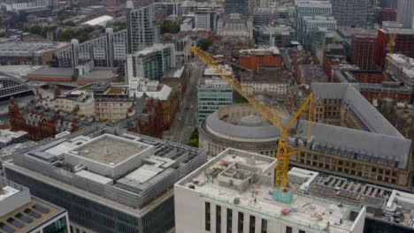 Drone-Shot-Pulling-Up-From-Construction-Crane-In-Manchester-City-Centre