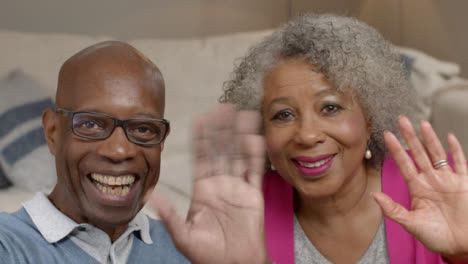 Older-Couple-Waving-Hello-and-Listening-During-Video-Phone-Call