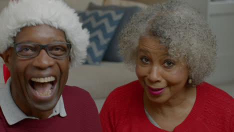 älteres-Ehepaar-Spricht-Und-Lacht-Während-Des-Weihnachtsvideoanrufs