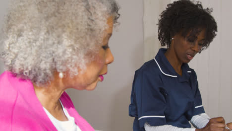 Krankenschwester-Mittleren-Alters,-Die-Hausbesuche-Im-Haus-Der-älteren-Frau-Durchführt