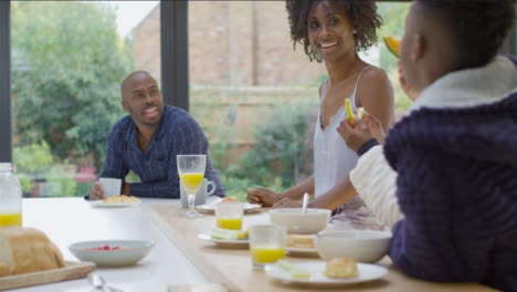 Family-Talking-and-Laughing-Together-Over-Breakfast-at-Kitchen-Island