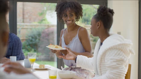 Mother-Hands-Plate-of-Croissants-to-Young-Daughter-During-Breakfast