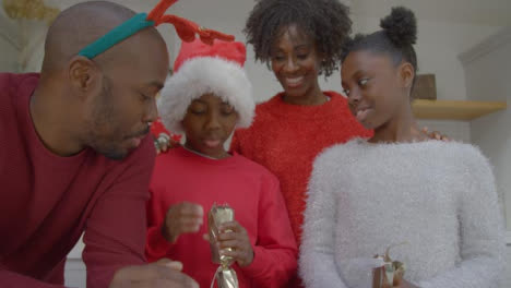 Fröhliche-Familie,-Die-Während-Des-Weihnachtsvideoanrufs-Hallo-Winkt-Und-Weihnachtscracker-Zieht