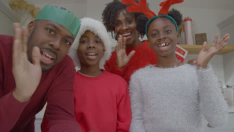 Fröhliche-Familie,-Die-Während-Des-Weihnachtsvideoanrufs-Hallo-Winkt-Und-In-Die-Webcam-Spricht