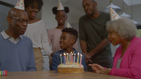 Family-Singing-Happy-Birthday-for-Young-Boy-Relative-Before-He-Blows-Out-Candles