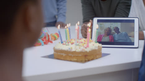 Family-Having-Video-Call-with-Grandparents-Singing-Happy-Birthday-for-Young-Girl