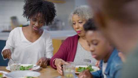 Familia-Sentada-Alrededor-De-Una-Mesa-Cenando-Juntos