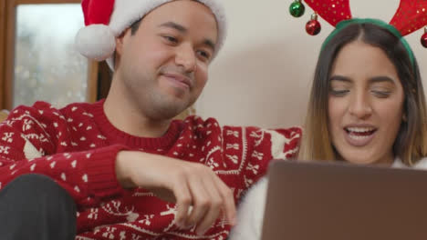 Aufsteigende-Nahaufnahme-Eines-Paares,-Das-Während-Eines-Weihnachtsvideoanrufs-In-Einen-Laptop-Spricht
