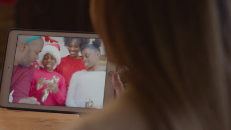Over-the-Shoulder-Shot-of-Woman-Talking-to-Family-During-Christmas-Video-Call