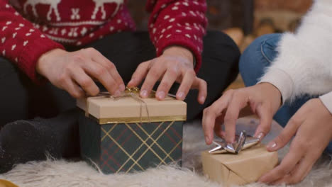 Rising-Close-Up-Shot-of-Young-Couple-Wrapping-Christmas-Presents-Together