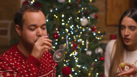 Close-Up-Shot-of-Couple-Drinking-Champagne-and-Eating-During-Christmas-Celebrations