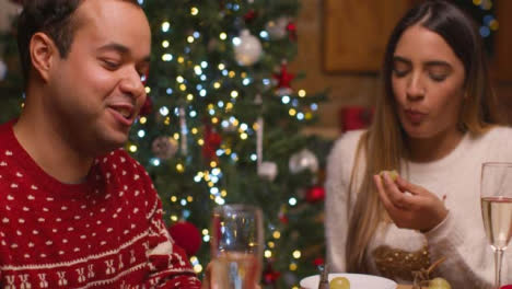 Rising-Shot-of-Young-Couple-Eat-a-Table-Spread-Together-During-Christmas-