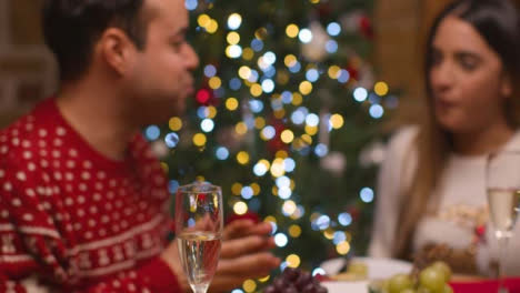 Defocused-Shot-of-Young-Couple-Enjoying-Food-Spread-During-Christmas-Celebrations-