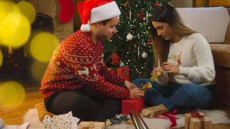 Wide-Shot-of-a-Young-Couple-Wrapping-a-Christmas-Gift-Together-