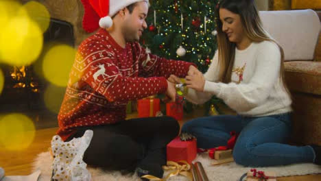 Weitwinkelaufnahme-Eines-Fröhlichen-Jungen-Paares,-Das-Zusammen-Weihnachtsgeschenke-Verpackt