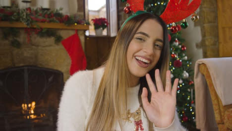 Young-Woman-Talking-and-Waving-to-Camera-During-Christmas-Video-Call