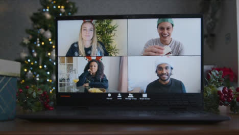 Close-Up-Shot-of-4-Way-Split-Screen-Christmas-Themed-Group-Video-Call-Amongst-Friends-On-Laptop