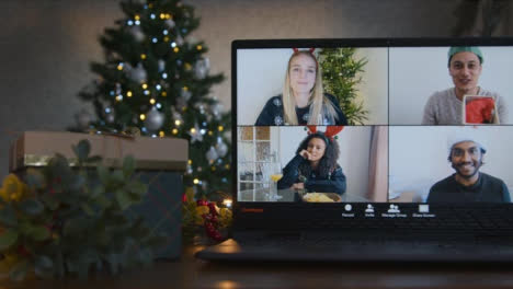 Sliding-Close-Up-Shot-of-4-Way-Split-Screen-Christmas-Themed-Group-Video-Call-Amongst-Friends-On-Laptop