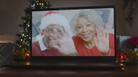 Close-Up-Shot-of-Senior-Couple-During-Video-Call-On-Laptop-Screen-In-Christmas-Environment