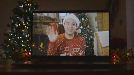 Close-Up-Shot-of-Young-Man-During-Video-Call-On-Laptop-Screen-In-Christmas-Environment