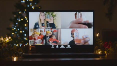 Sliding-Shot-Approaching-Laptop-Screen-with-4-Way-Split-Screen-of-Friends-Raising-Glasses-In-Video-Call