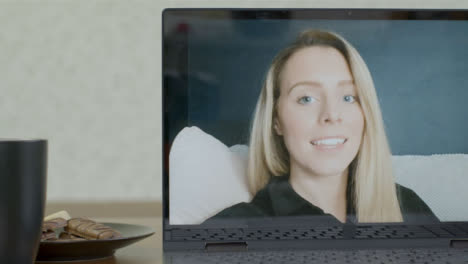 Sliding-Medium-Shot-of-Laptop-Screen-with-Young-Woman-On-a-Video-Call