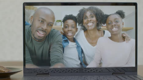Sliding-Medium-Shot-of-Laptop-Screen-with-Family-On-Video-Call