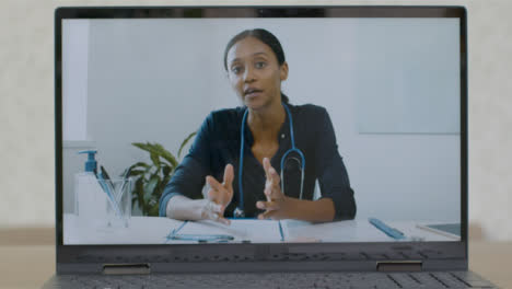 Sliding-Medium-Shot-of-Laptop-Screen-with-Doctor-On-a-Video-Call