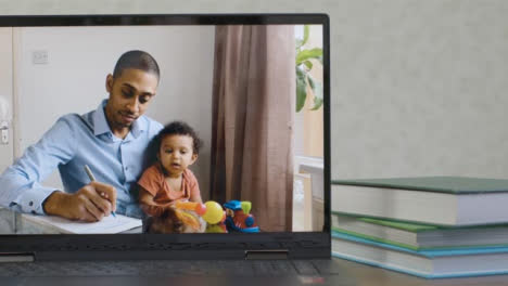 Sliding-Medium-Shot-of-Laptop-Screen-with-Working-Father-and-Baby-On-a-Video-Call