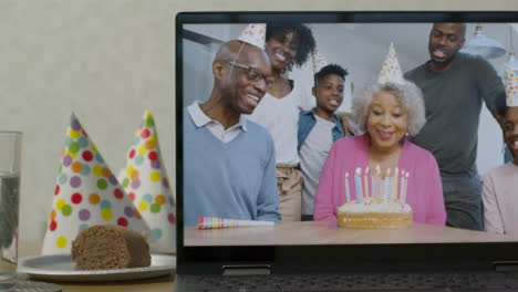 Sliding-Medium-Shot-of-Laptop-Screen-with-Family-Singing-Happy-Birthday-On-Video-Call