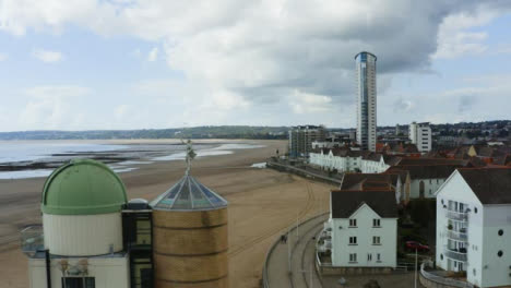 Drone-Shot-Orbiting-Apartment-Buildings-On-Beach-In-Swansea