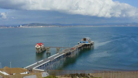 Drone-Shot-Rising-Over-Cliff-Face-Revealing-Mumbles-Pier-In-Swansea-01