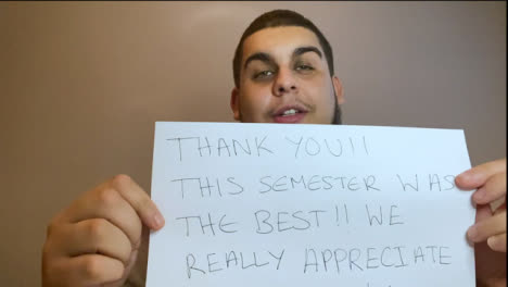 Young-University-Student-Holding-Up-Thank-You-Sign-During-Video-Lecture