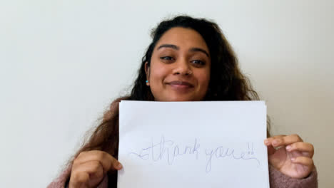 A-Young-Female-Student-Holding-Up-Thank-You-Sign-During-Video-Lecture