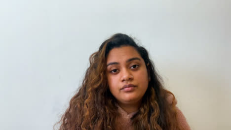 A-Young-Female-Student-Visibly-Bored-Whilst-Looking-Directly-into-Camera-During-Remote-Lecture