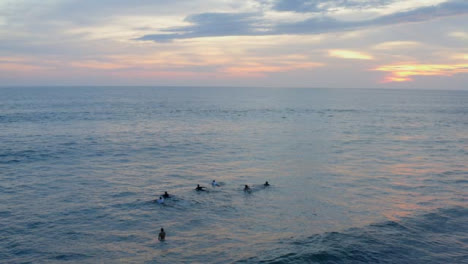 Drone-Shot-Orbiting-Surfers-Swimming-Out-to-Sea