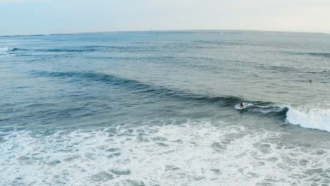 Drone-Shot-Following-a-Surfer-Riding-Wave-Off-Echo-Beach-Coast