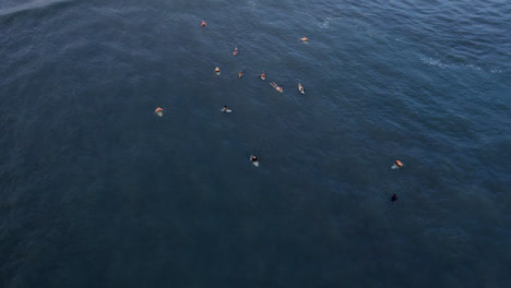 Disparo-De-Drone-Orbitando-Un-Grupo-De-Surfistas-Esperando-Olas