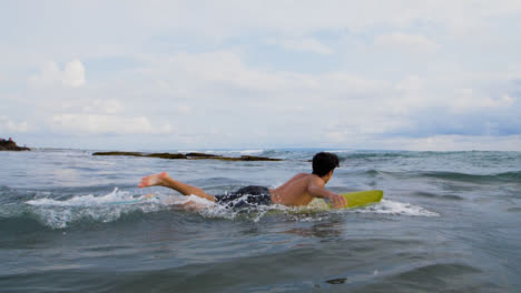 Handheld-Breitbild-Eines-Jungen-Surfers,-Der-Ins-Meer-Läuft