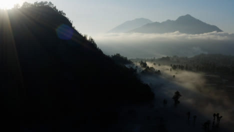 Drone-Shot-Volando-Sobre-La-Niebla-Que-Cuelga-Baja-Que-Rodea-El-Monte-Batur