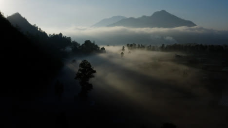 Drone-Shot-Pasando-Por-Debajo-De-La-Niebla-Que-Cuelga-Que-Rodea-El-Monte-Batur