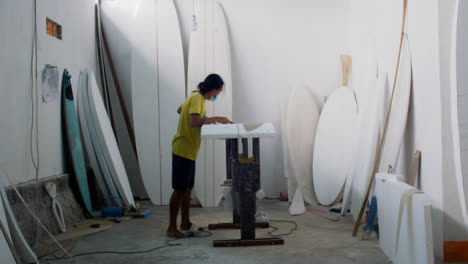 Handheld-Weitwinkelaufnahme-Eines-Surfboard-Shapers-In-Ihrer-Werkstatt