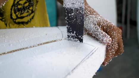 Handheld-Close-Up-Shot-of-a-Surfboard-Shaper-Cutting-Polystyrene-Board