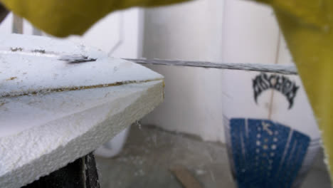 Handheld-Close-Up-Shot-of-Surfboard-Shaper-Cutting-Polystyrene-Board