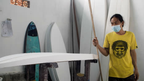 Handheld-Weitwinkelaufnahme,-Die-Surfboard-Shaper-In-Der-Werkstatt-Aufdeckt