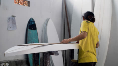 Handheld-Weitwinkelaufnahme,-Die-Einen-Surfboard-Shaper-In-Der-Werkstatt-Enthüllt