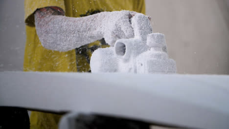 Handheld-Long-Shot-of-a-Surfboard-Shaper-Using-Power-Tool-On-Polystyrene-Surfboard