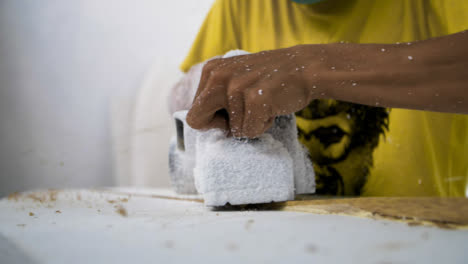 Handheld-Close-Up-Shot-of-Power-Tool-Being-Used-On-a-Polystyrene-Surfboard