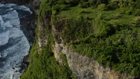 Drone-Shot-Orbiting-People-Standing-Near-Uluwatu-Cliff-Edge-