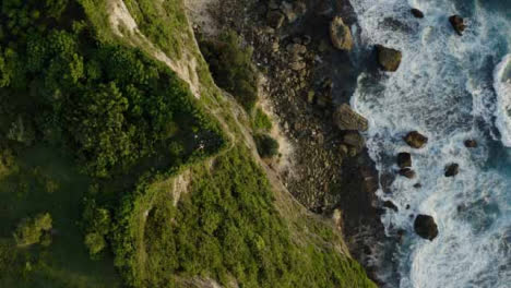 Drone-Shot-Ascendiendo-Por-Encima-De-Un-Grupo-De-Personas-Socializando-Cerca-Del-Borde-Del-Acantilado